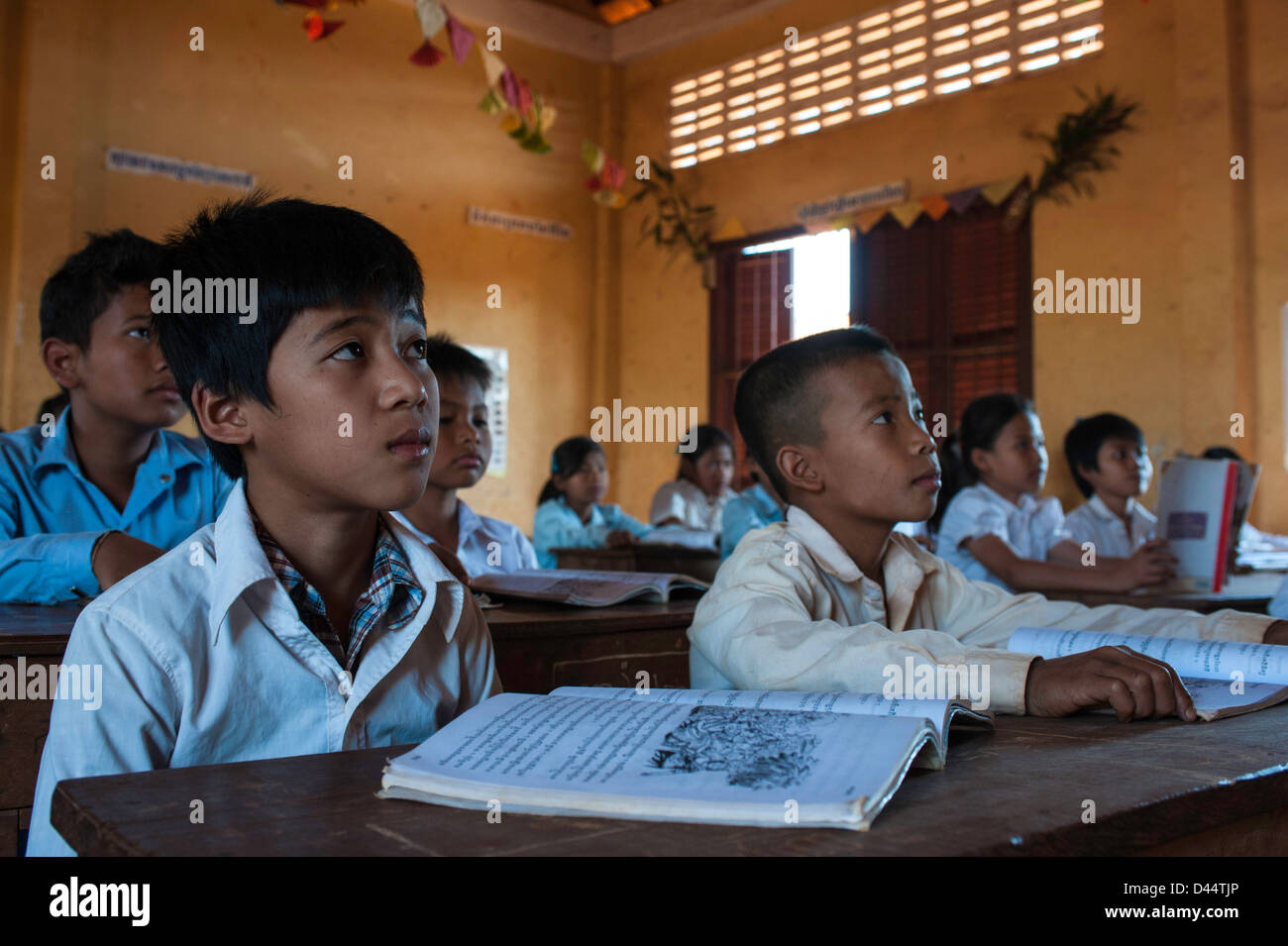 Giovani studenti di Banlung Ratanakir ascoltando il loro insegnante in una classe in Cambogia Foto Stock