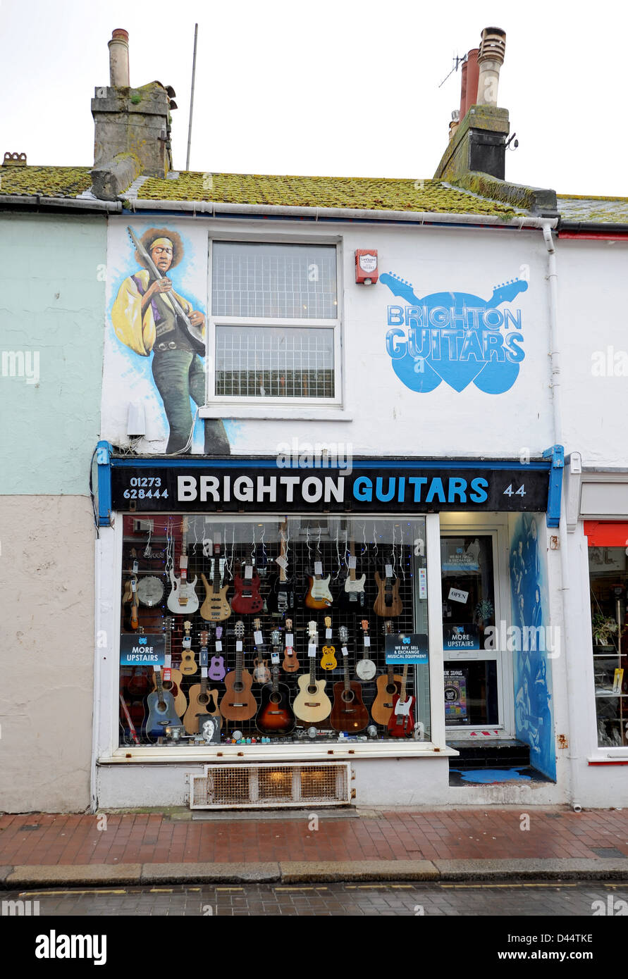 Brighton chitarre store in North Laine area di Brighton con un Jimi Hendrix murale sulla parete Foto Stock