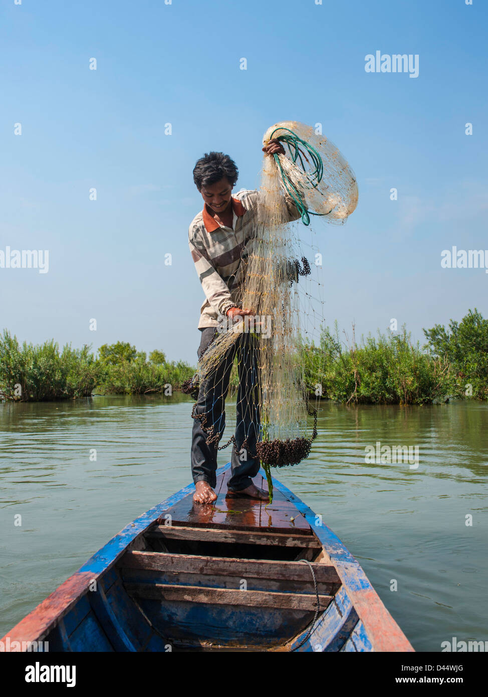 Uomo tribali di pesca con net lungo il fiume Mekong in Cambogia. Foto Stock