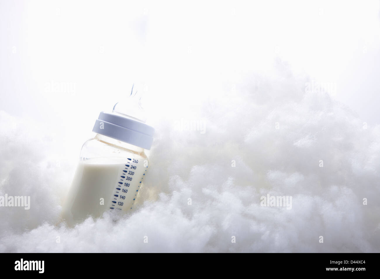 Baby bottiglia di latte su bianco cotoni Foto Stock