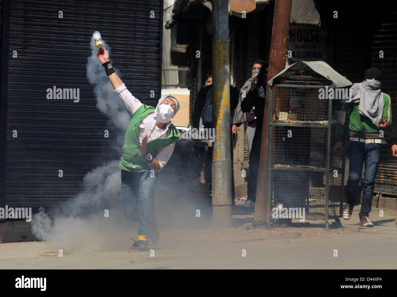 5 marzo 2013 - Srinagar Kashmir, India - un manifestante Kashmir getta indietro di un gas lacrimogeni guscio verso indiano poliziotti durante uno scontro tra i dimostranti e la polizia indiana a Srinagar, la capitale estiva del Kashmir indiano. La vita normale è stato colpito per il secondo giorno consecutivo oggi a causa di un marzo chiamato da un gruppo di separatisti per la residenza di un allievo del Kashmir, che è stato trovato appeso nella sua camera di ostello a Hyderabad. Le autorità hanno distribuito di polizia e paramilitari personale in grandi numeri in Kashmir a sud della città di Pulwama, l'area locale di Mudasir Kamran, (25) che è stato trovato appeso alla Foto Stock