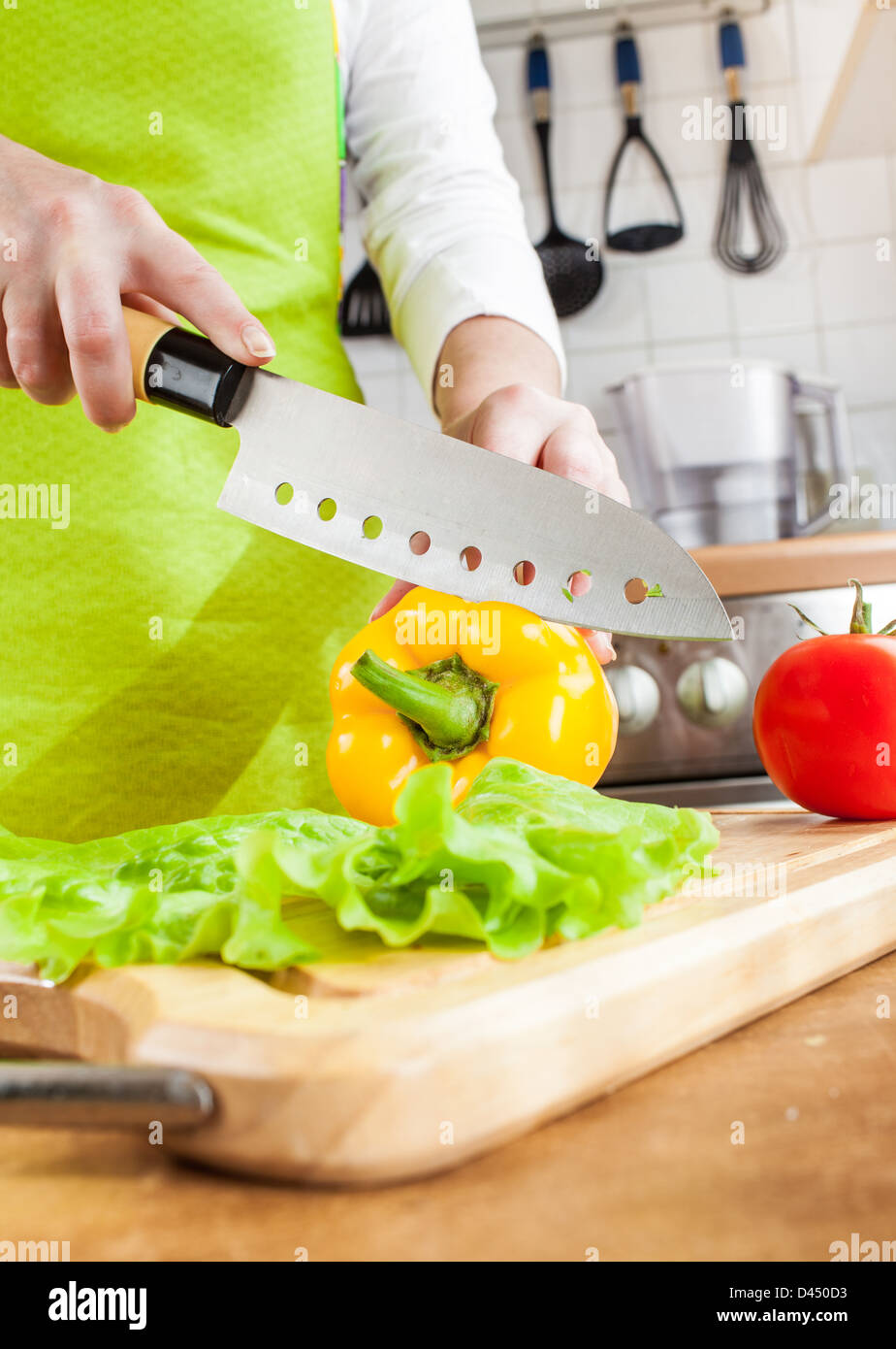 Donna di mani fresche di taglio il peperone su cucina Foto Stock