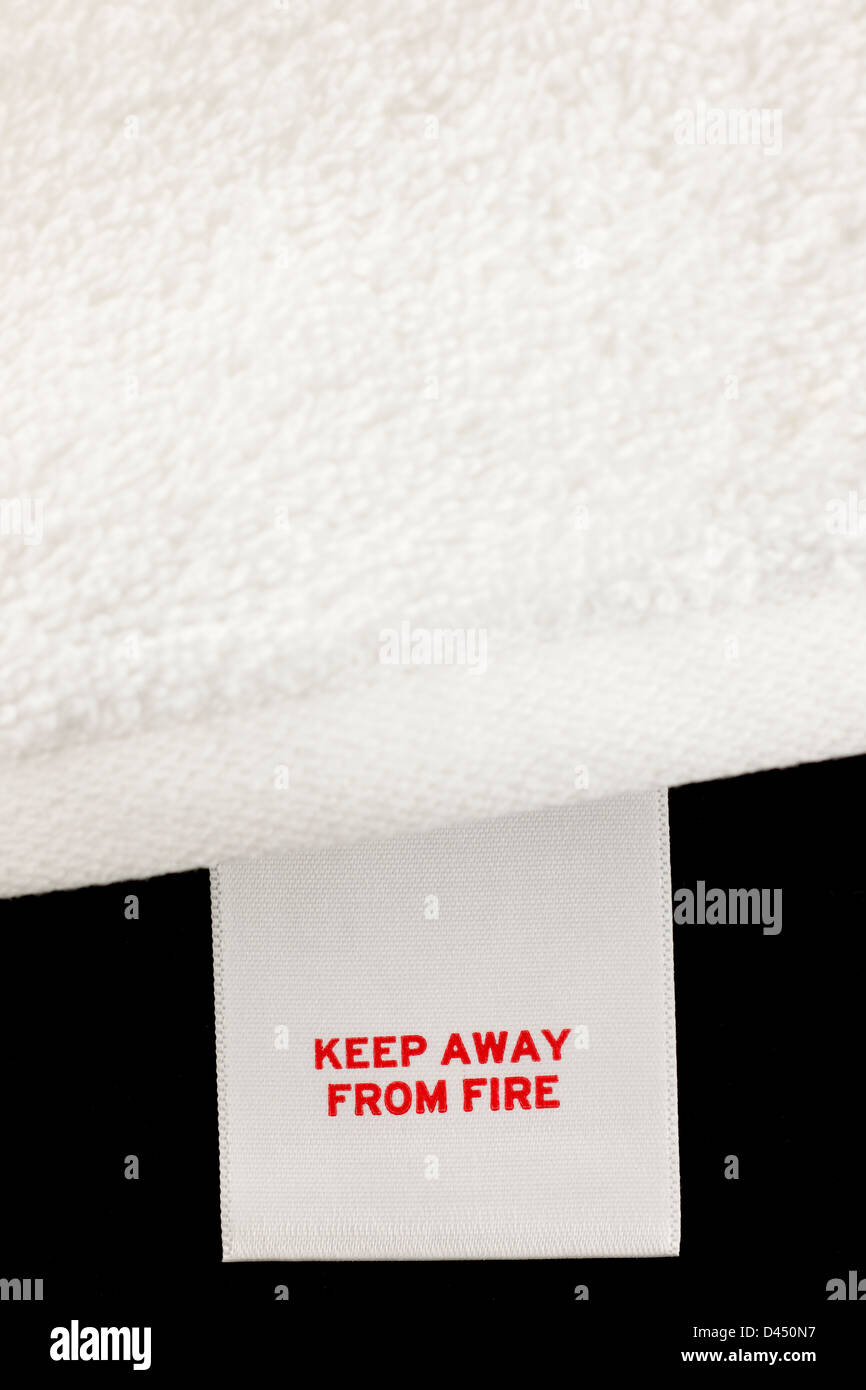 Tenere lontano dal fuoco di etichetta su un asciugamano bianco Foto Stock