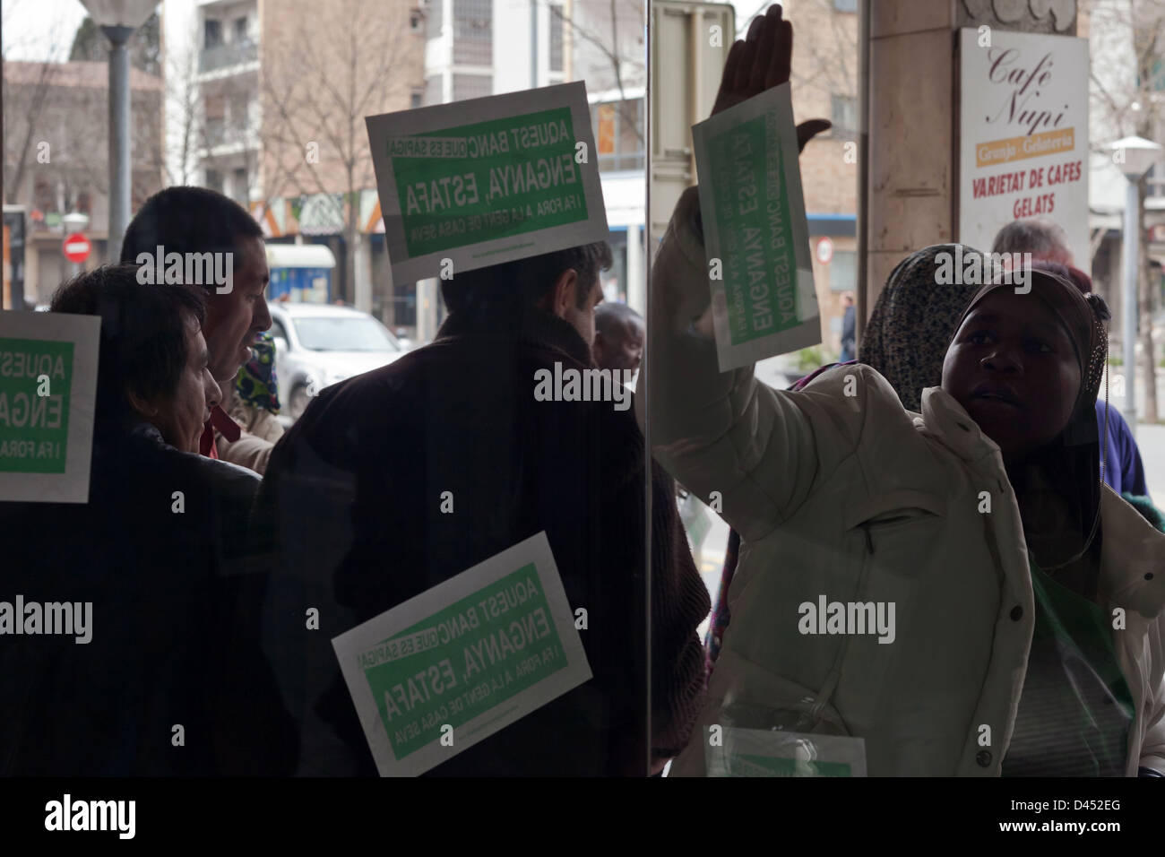 Miembros de la PAH Girona enganchan carteles en n.a. oficina del BBVA en sale, duranti onu acto de protesta Foto Stock