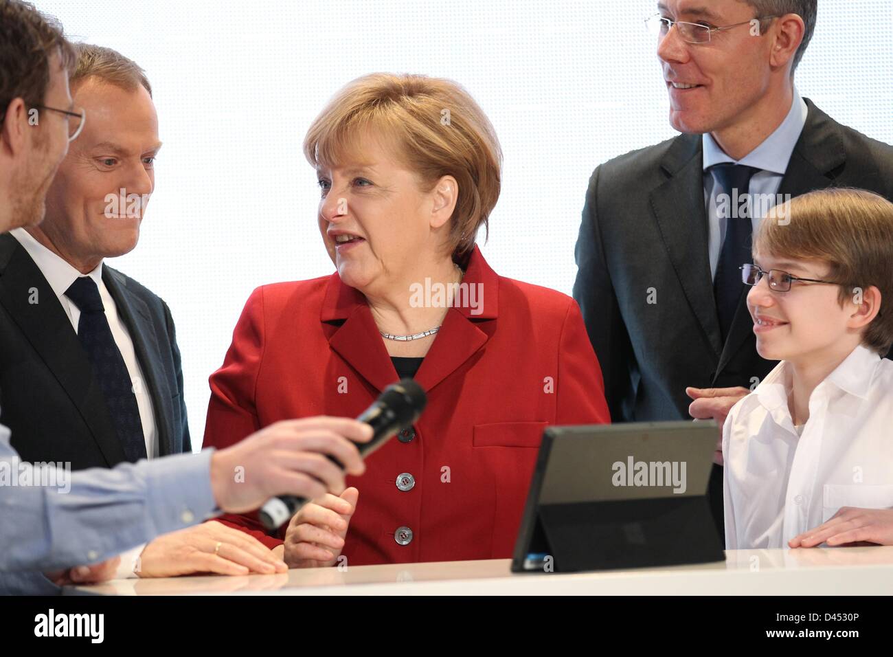 Primo ministro della Polonia Donald Tusk (L-R), il Cancelliere tedesco Angela Merkel, Christian P. Illek, presidente del consiglio di amministrazione di Microsoft Germania, e app-developer Felix Guttbier stand presso lo stand di Microsoft durante il round di apertura tour del più grande del mondo di computer expo CeBIT di Hannover, Germania, 05 marzo 2013. Foto: FRISO GENTSCH Foto Stock