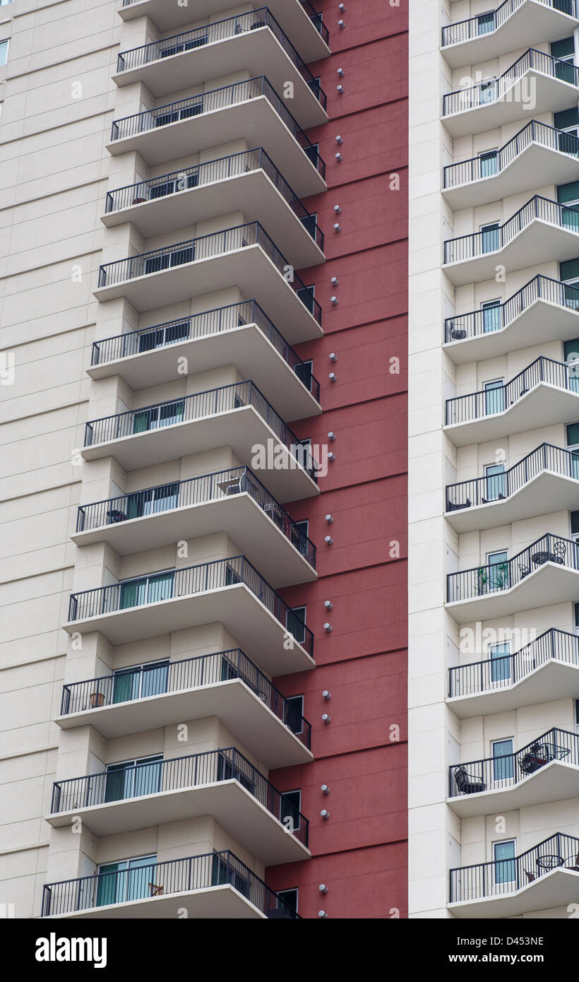Una colonna di balcones su un elevato aumento condominio con una torre rossa parete in stucco Foto Stock