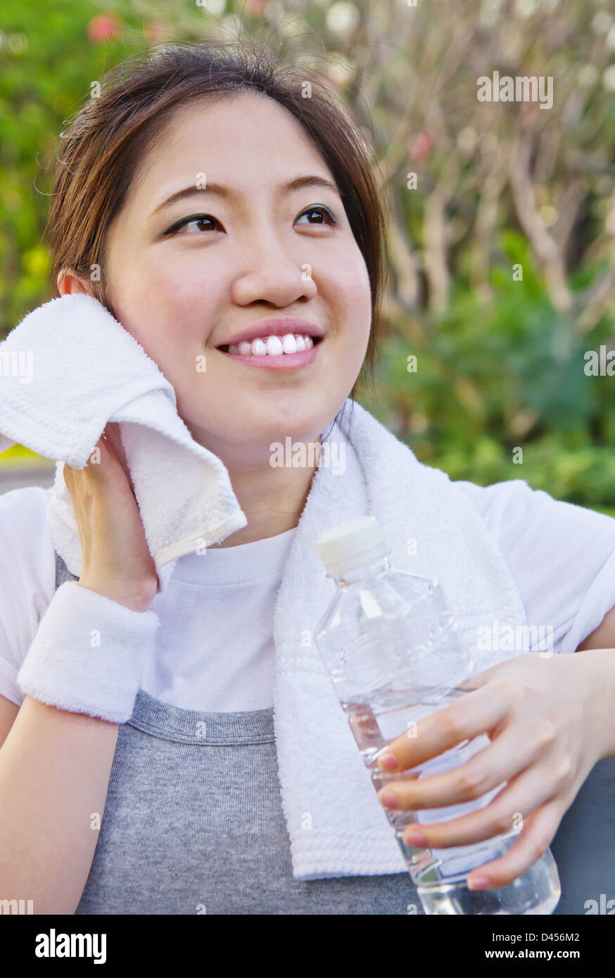Donna asiatica tergi sudore con un asciugamano dopo esercizio Foto Stock