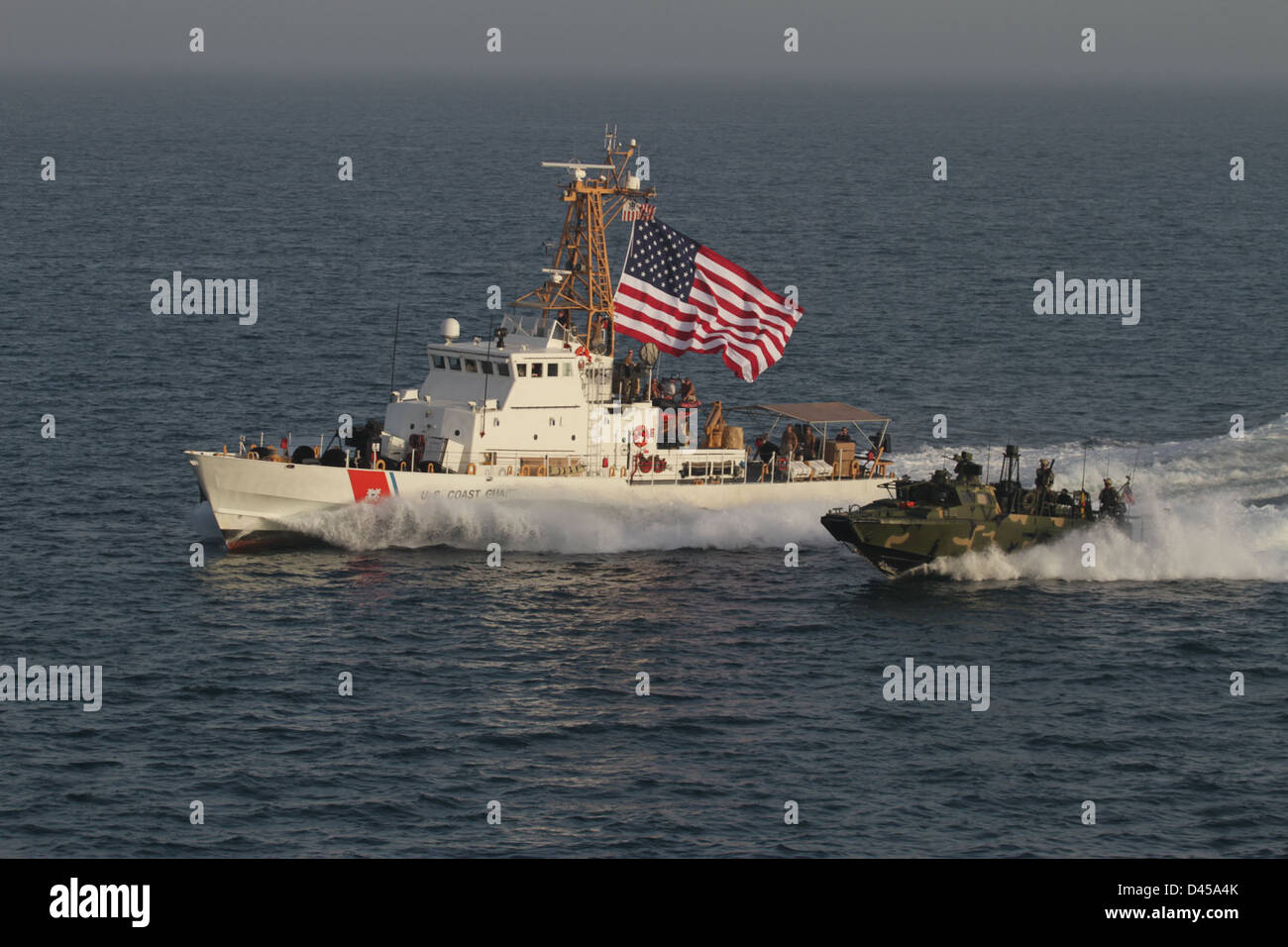 Un comando fluviale velocità delle imbarcazioni a fianco degli Stati Uniti Guardacoste Adak. Foto Stock