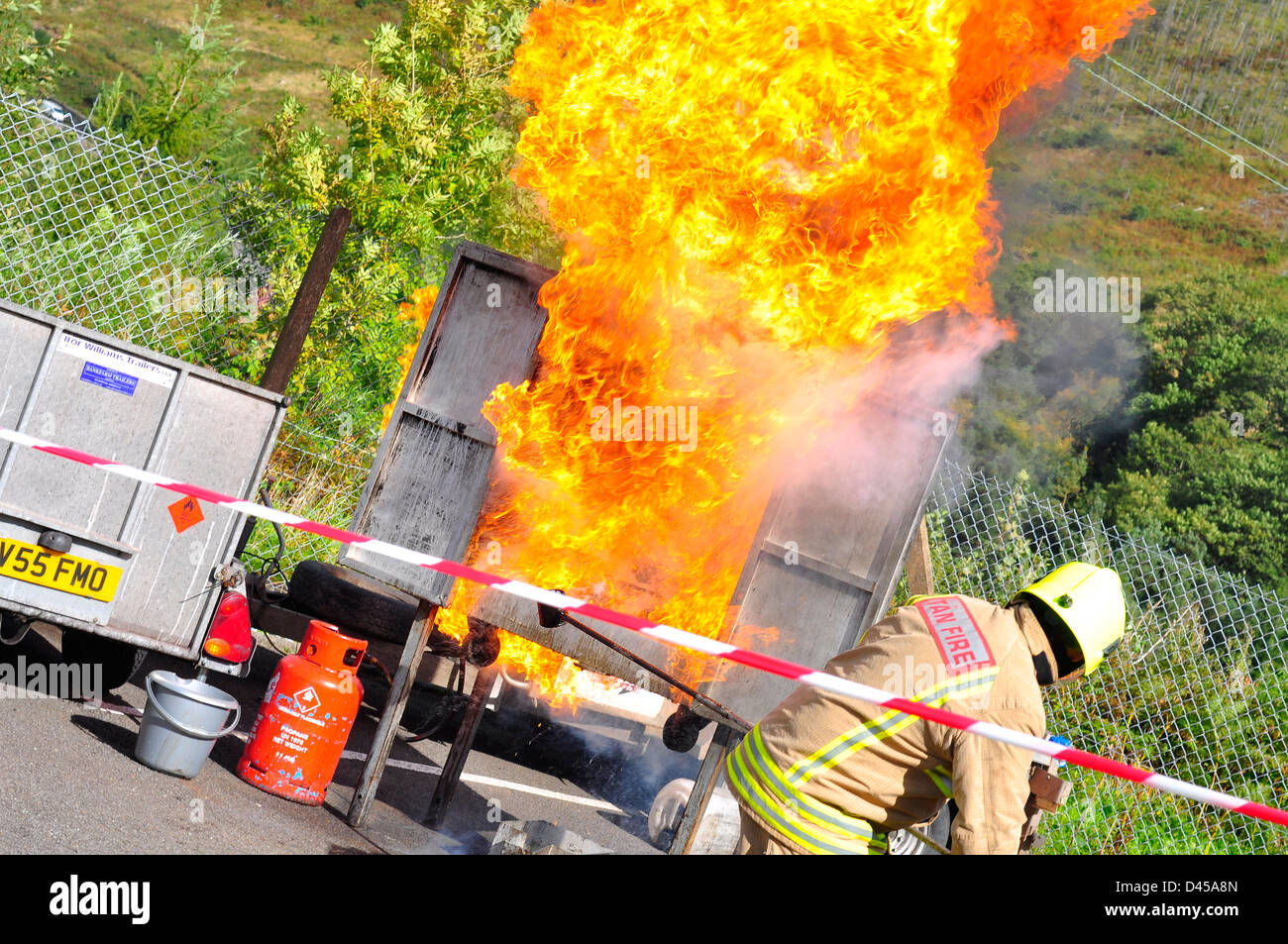 Un vigile del fuoco visualizza la gravità di acqua su un chip pan fire Foto Stock