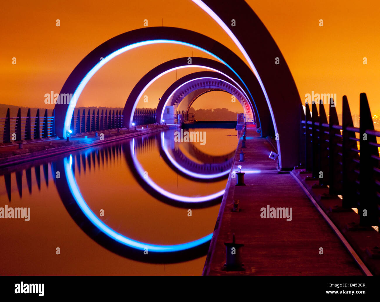 Una vista del Falkirk Wheel durante la notte con un bagliore arancione causato dai lampioni di Falkirk. Foto Stock