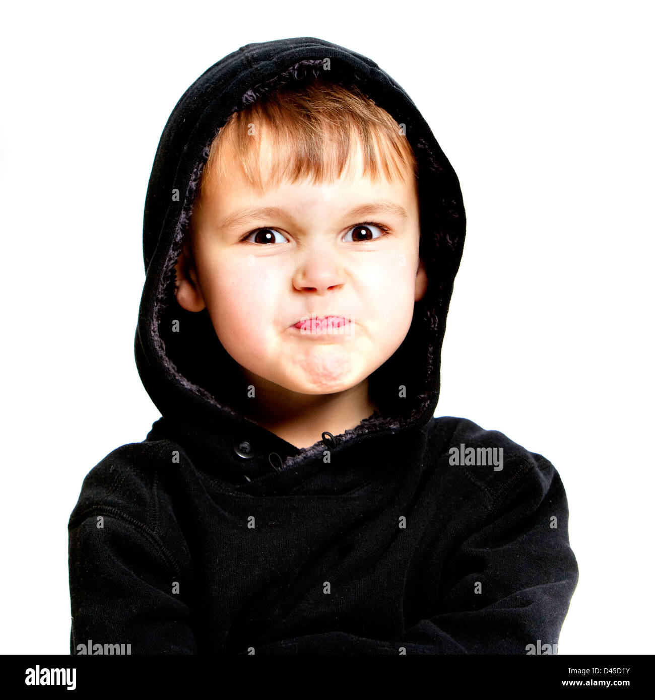 Cinque anni di vecchio ragazzo in un nero felpa con cappuccio Felpa con sallow pelle marrone capelli e gli occhi castani contro uno sfondo bianco. Foto Stock