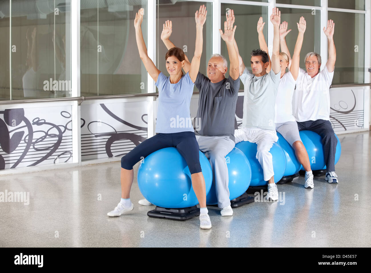 Classe di ginnastica per anziani felice sulla palla nel centro fitness Foto Stock