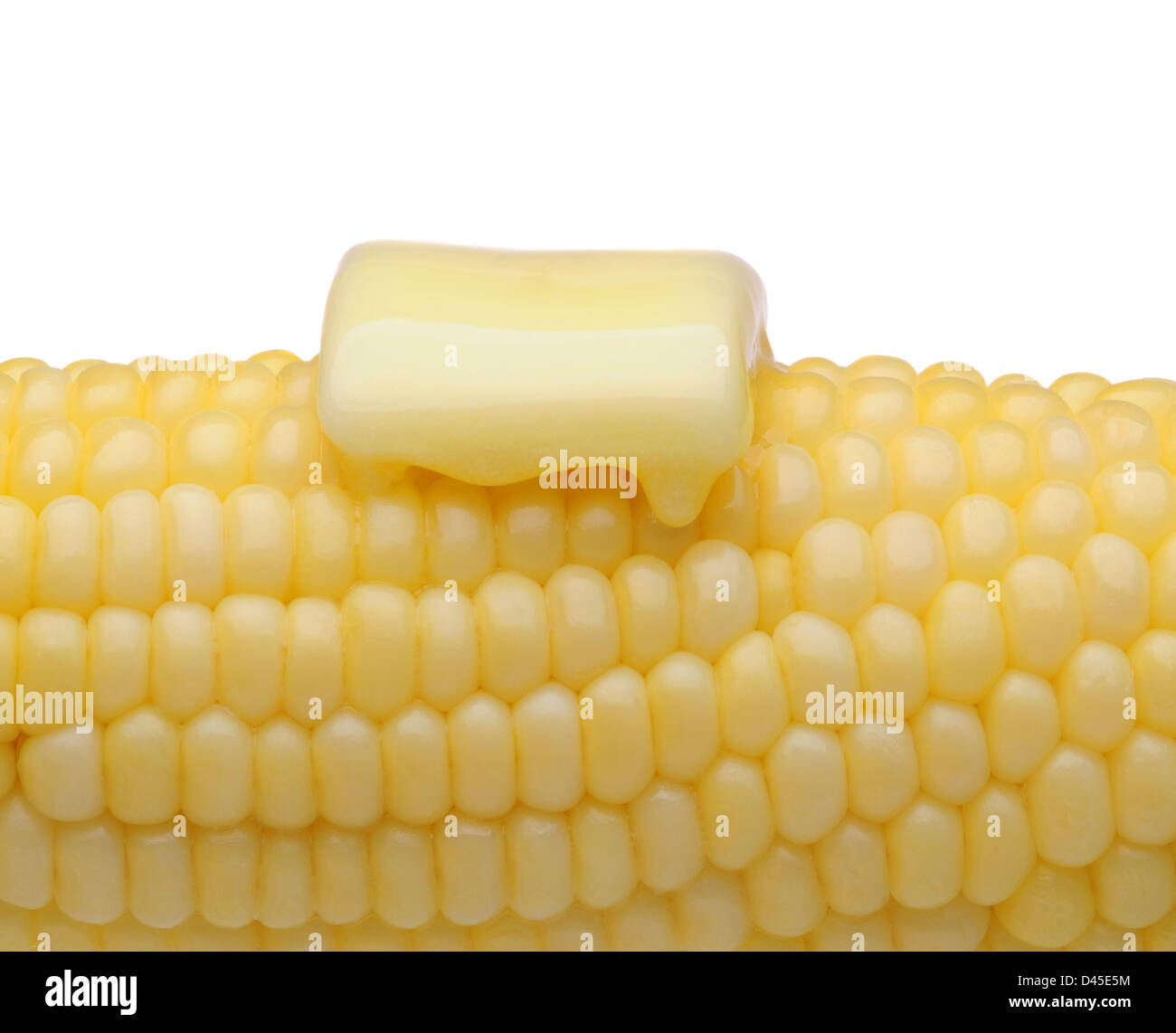 Primo piano di una pannocchia di mais con un pat di fondere il burro. Formato orizzontale sul bianco. Foto Stock
