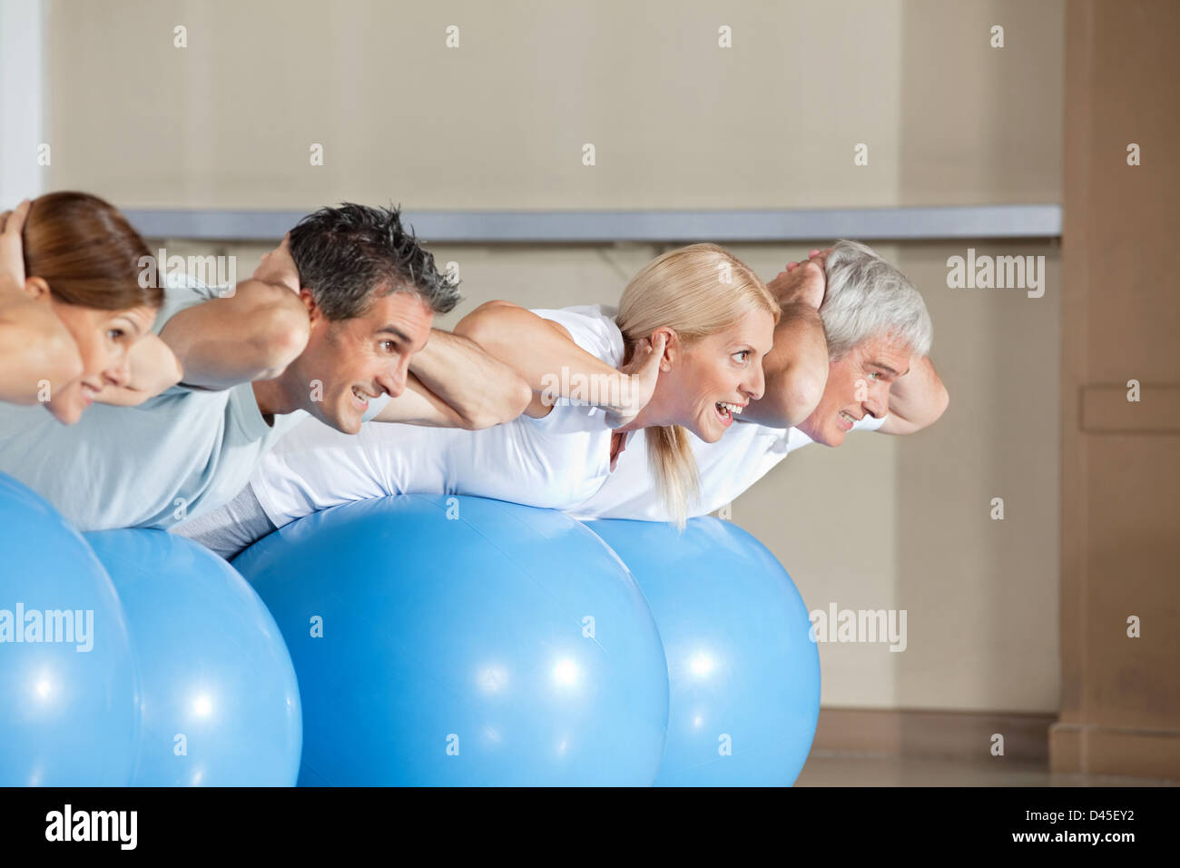 Senior di persone facendo scricchiola sulla palla nel centro fitness Foto Stock