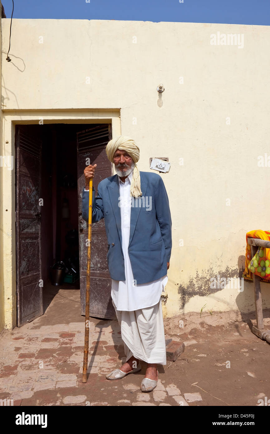 Tradizionalmente un vestito uomo Sikh sorge fuori la porta di casa sua nel Punjab India Foto Stock