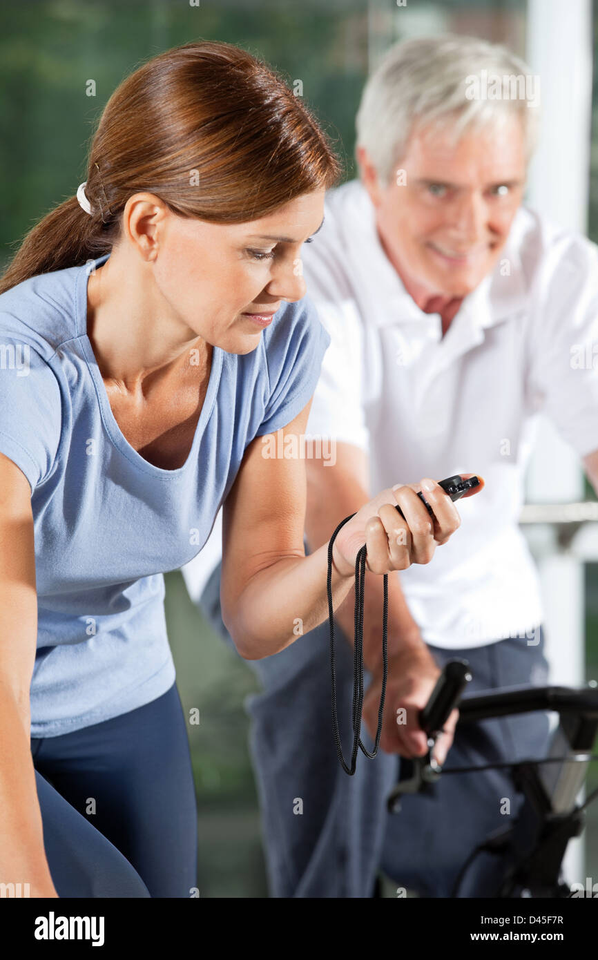 La donna nel centro fitness fermando il tempo con il cronometro Foto Stock