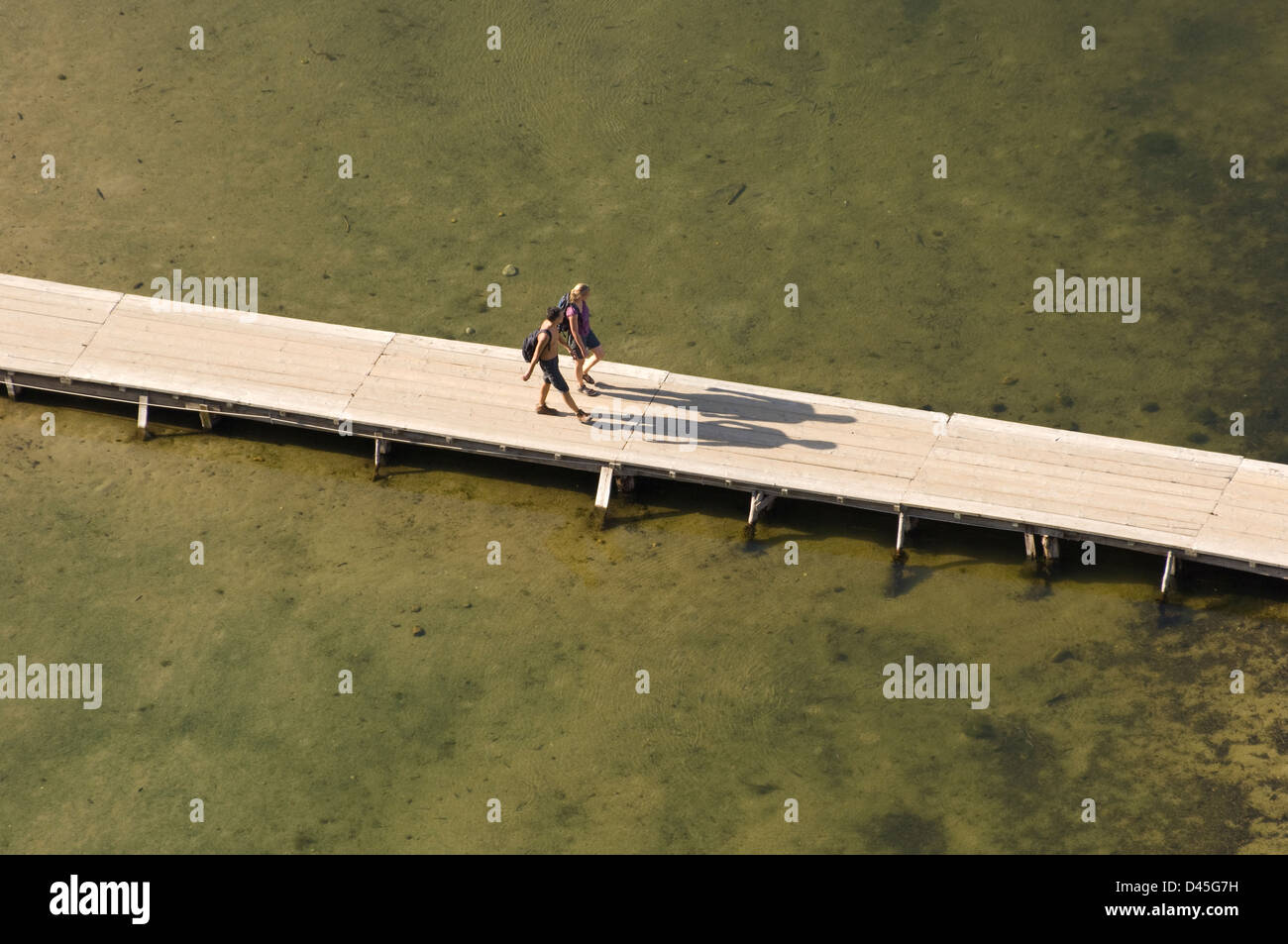 Giovane waPanoramic vista della famosa spiaggia di Cala lking sul ponte di Cala Luna spiaggia, Cala Gonone, Dorgali, Sardegna, Italia Foto Stock