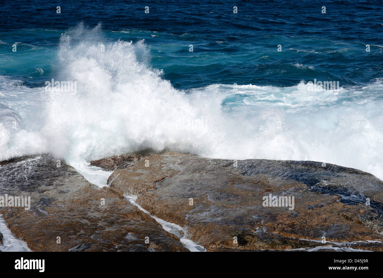 Oceano onde che si schiantano contro le rocce vicino a Bondi Foto Stock