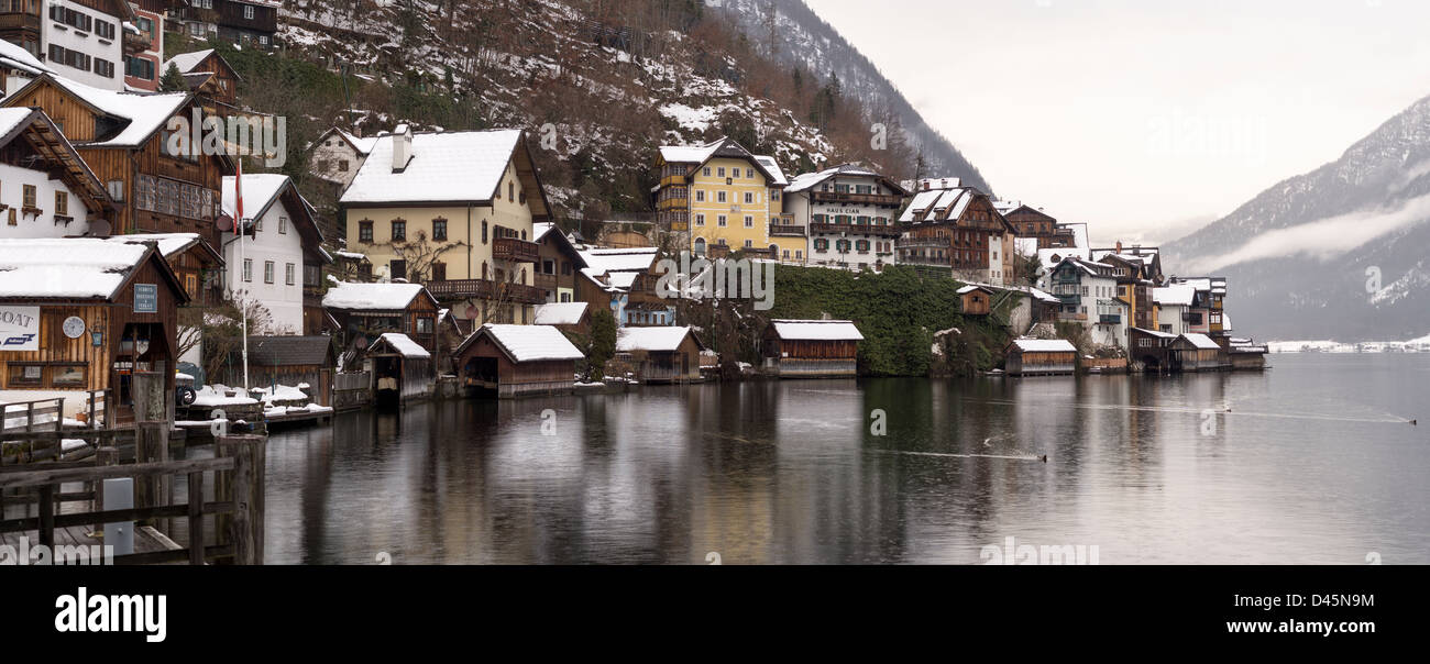 Hallstatt litorale sotto la pioggia con le anatre. Le case del borgo si riflette nella pioggia pezzata acqua del lago. Foto Stock