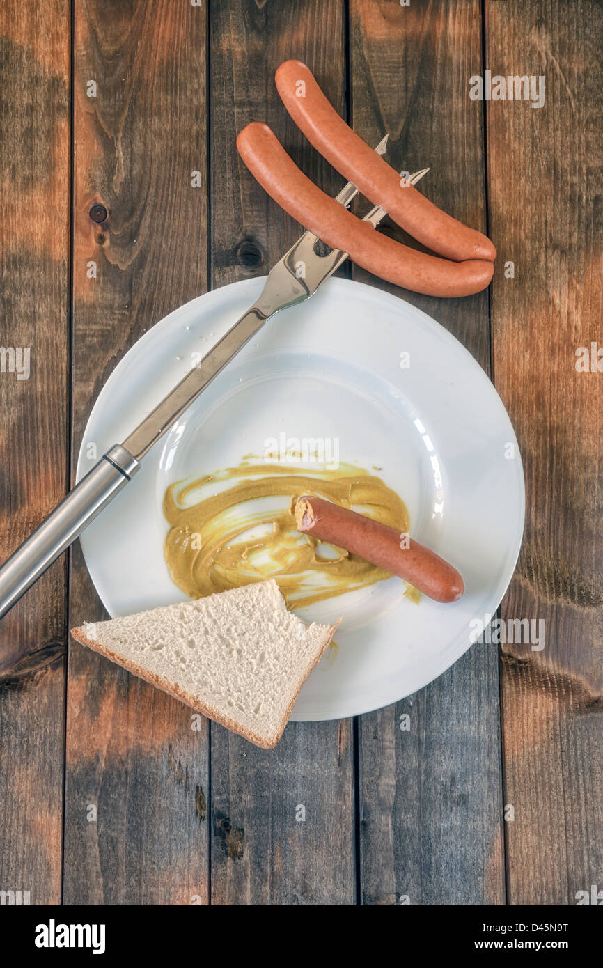 Mezza mangiata wiener con senape e pane tostato Foto Stock