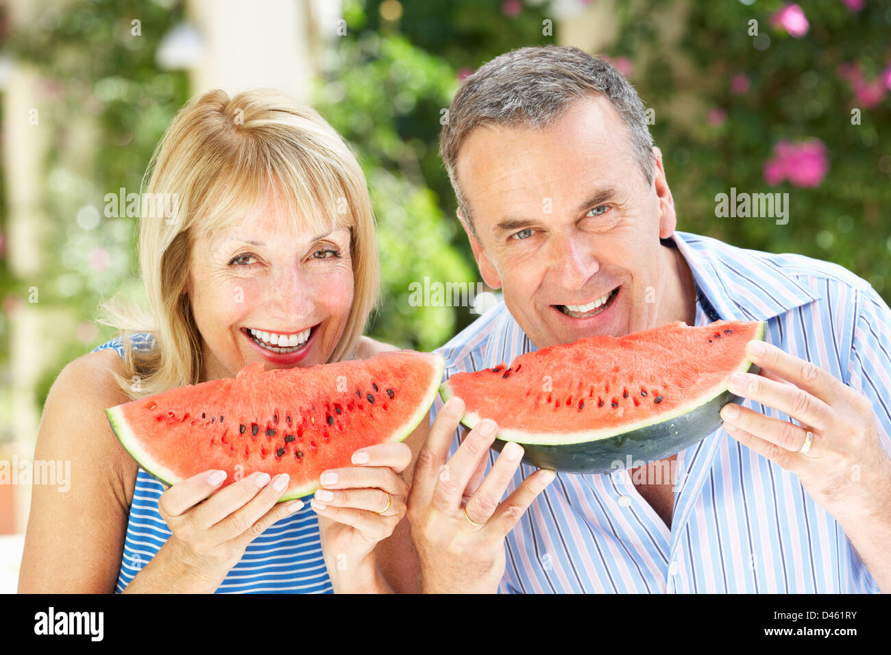 Coppia senior godendo le fette di melone acqua Foto Stock