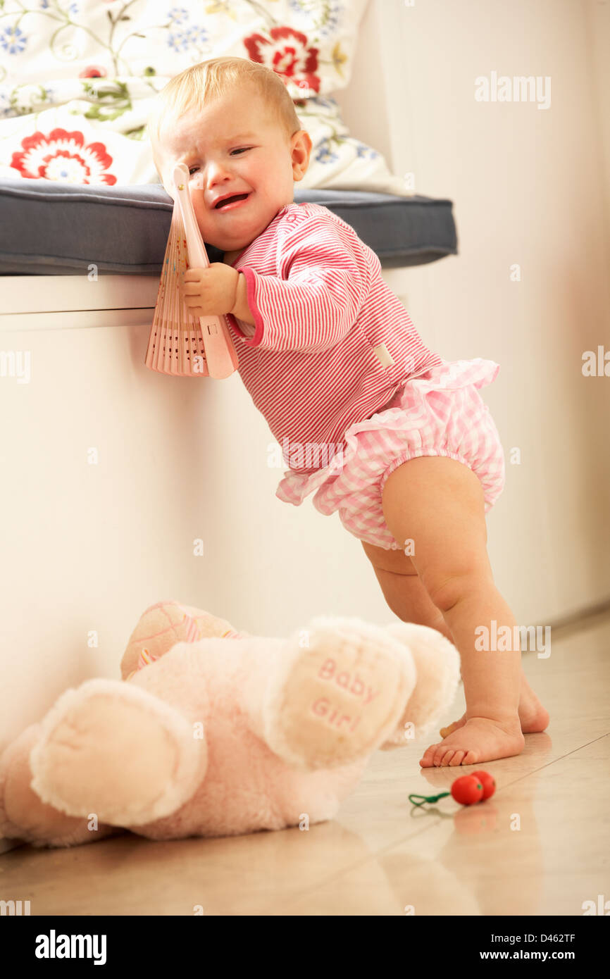 Sconvolto Baby girl imparare a stare a casa Foto Stock
