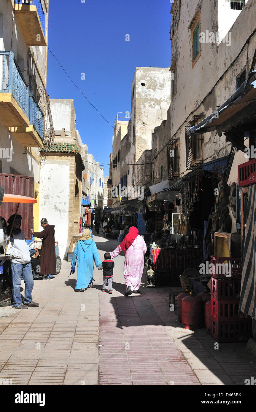 La popolazione locale a piedi attraverso le strade di mercato della fortificata città costiera di Essaouira, Marocco, Africa del Nord Foto Stock