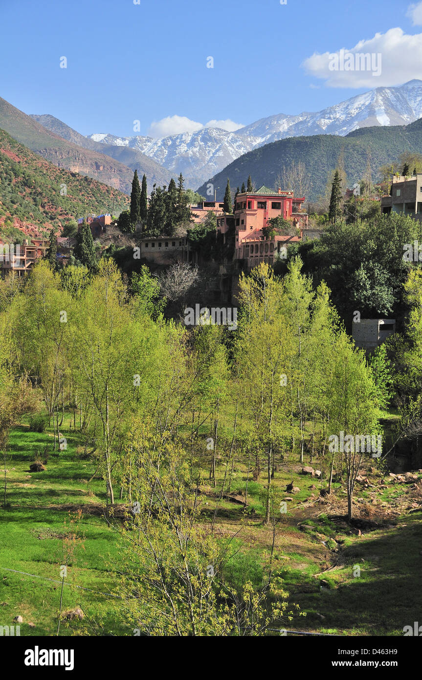 Vista del marocchino tradizionale villaggi a guidare l'Ourika Valley verso Setti Fatma, con vedute della coperta di neve Alto Atlante Marocco Foto Stock