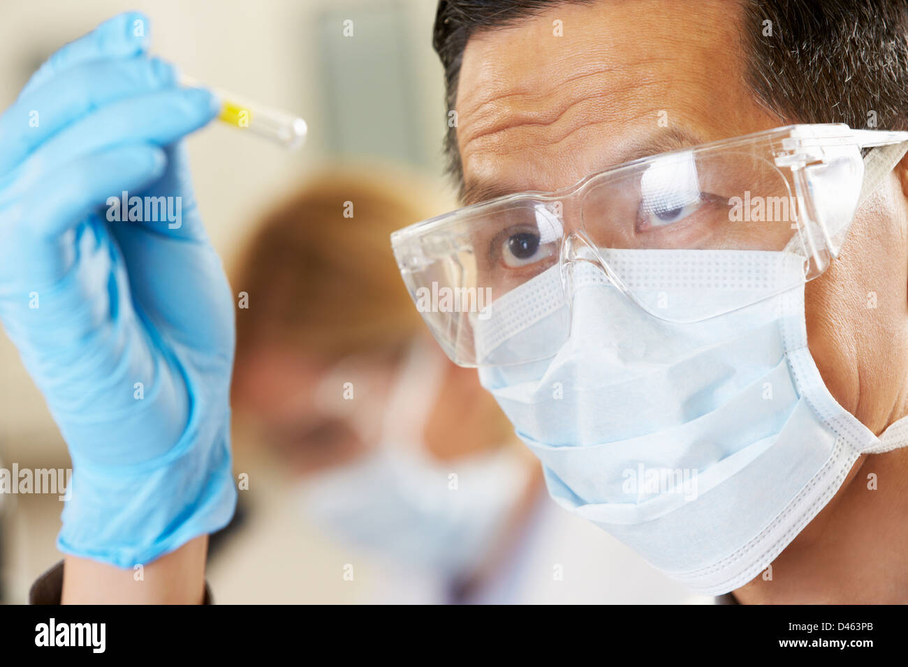 Scienziato maschio studiando provetta di test in laboratorio Foto Stock