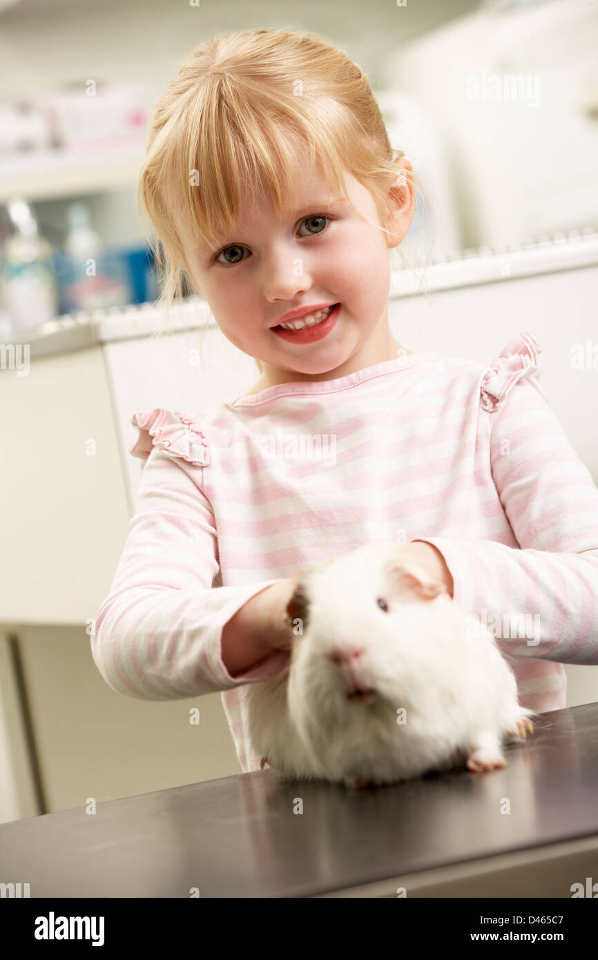 Bambino tenendo cavia per chirurgia veterinaria per esame Foto Stock