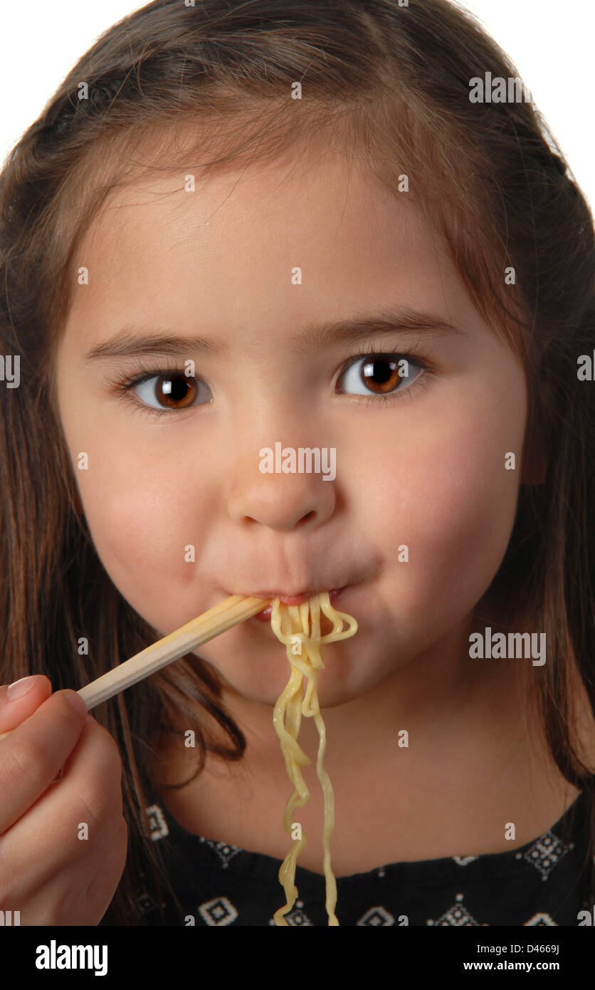 Ragazza giovane e carina di mangiare la zuppa di noodle con bacchette Foto Stock