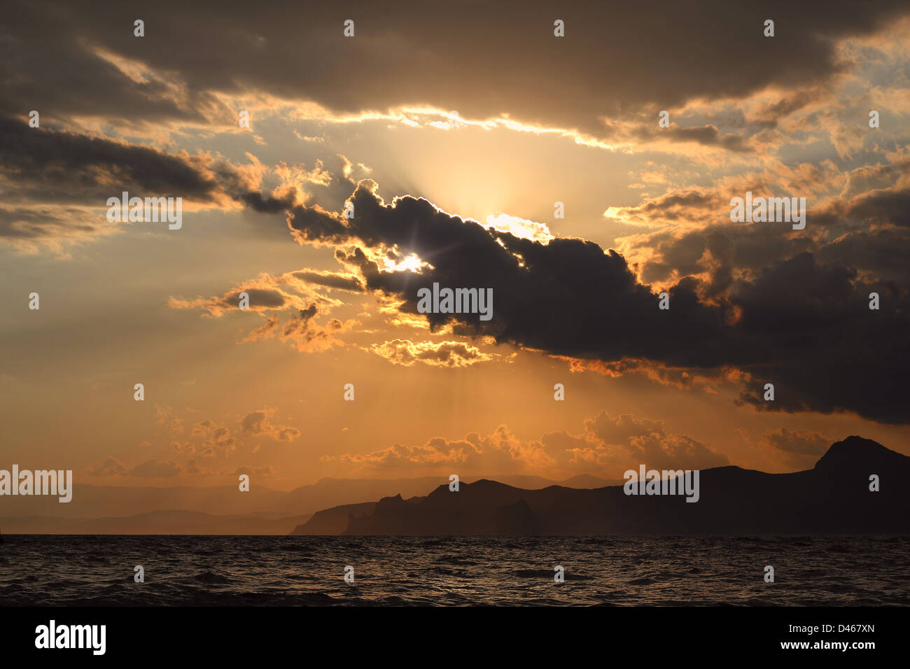 Tramonto sul mare in estate, contro lo sfondo delle montagne come un drago Foto Stock
