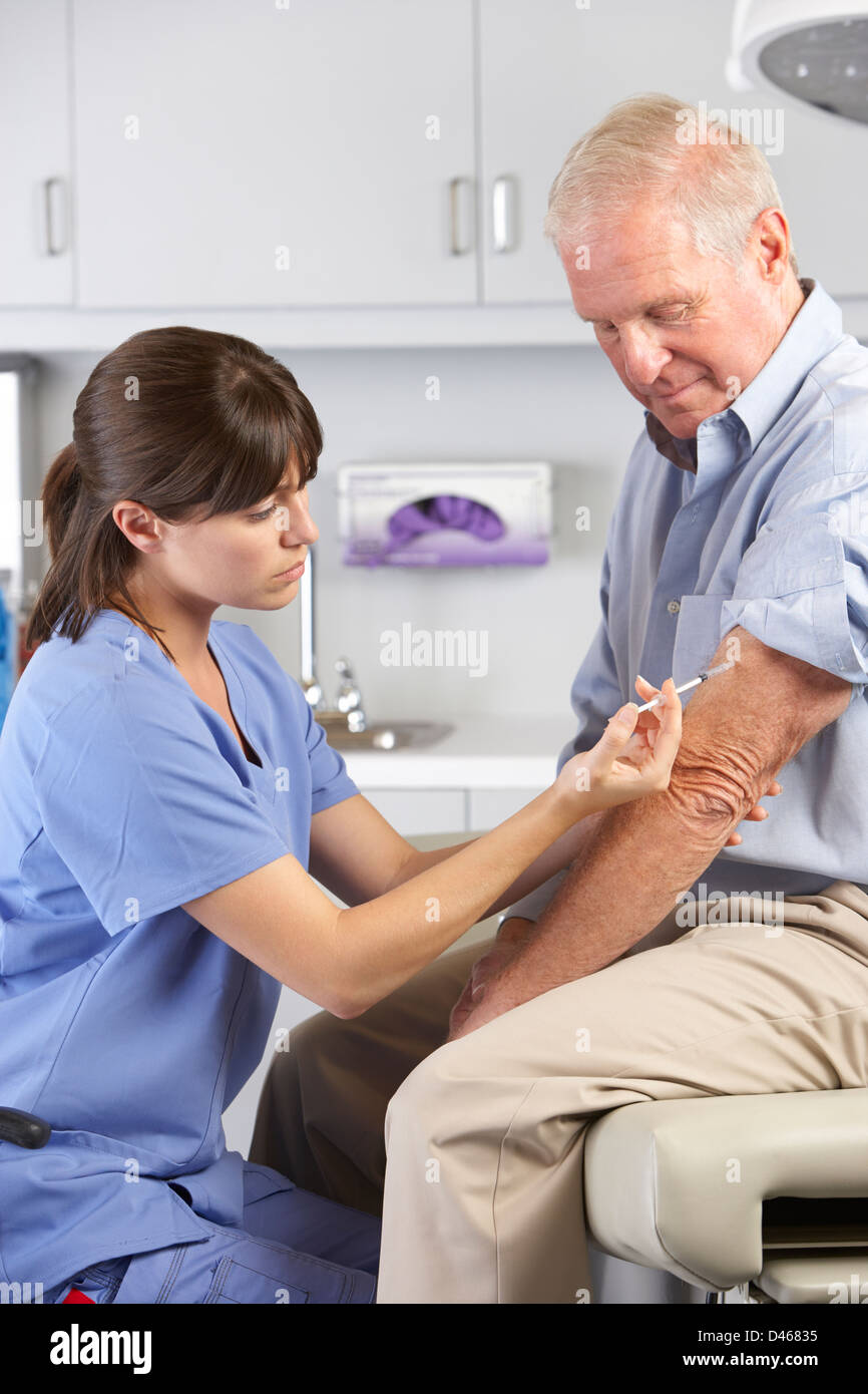 Medico dando maschio iniezione del paziente Foto Stock