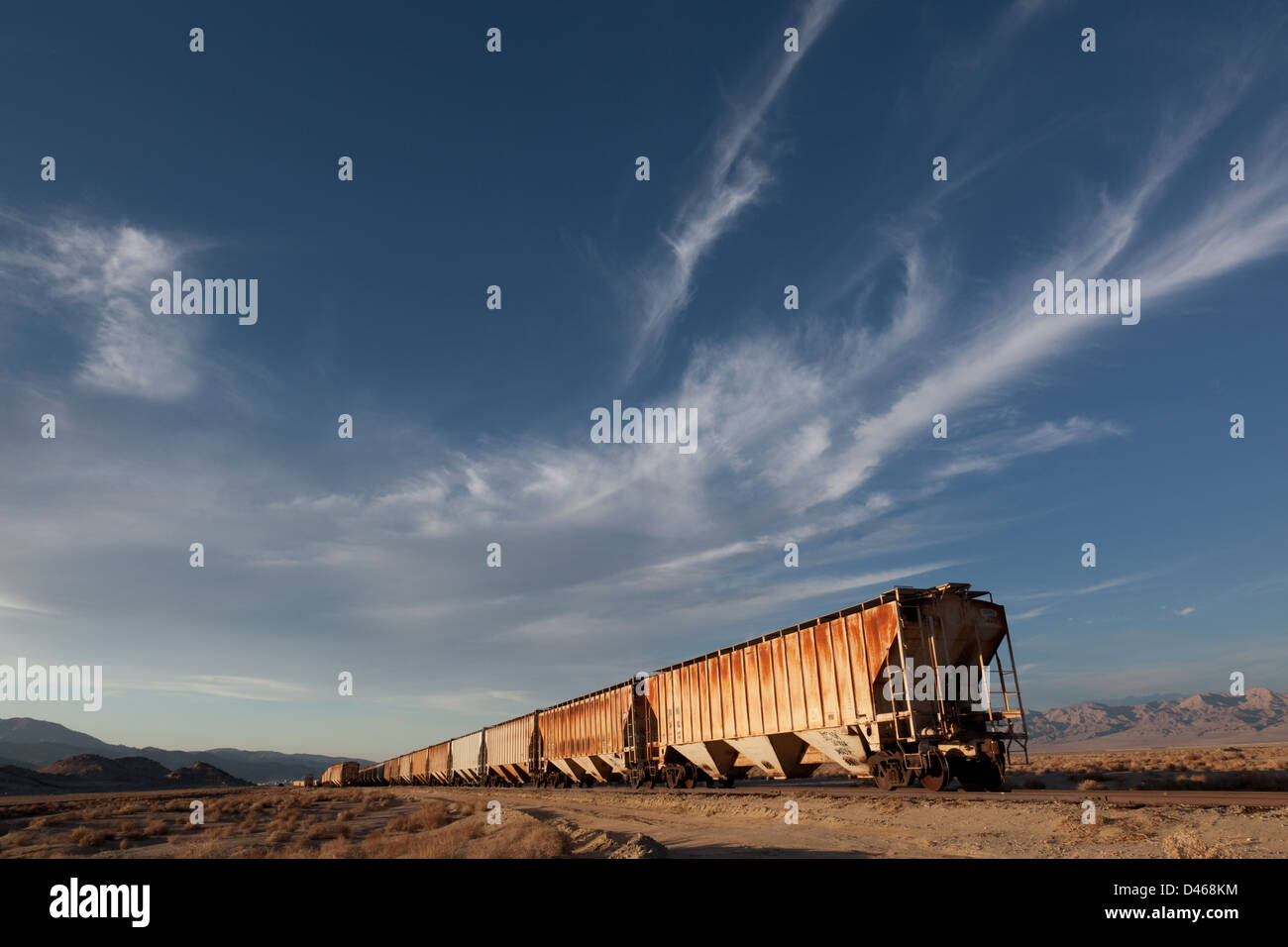 Un treno merci parcheggiato in una schierata nel deserto californiano nei pressi di Trona Foto Stock