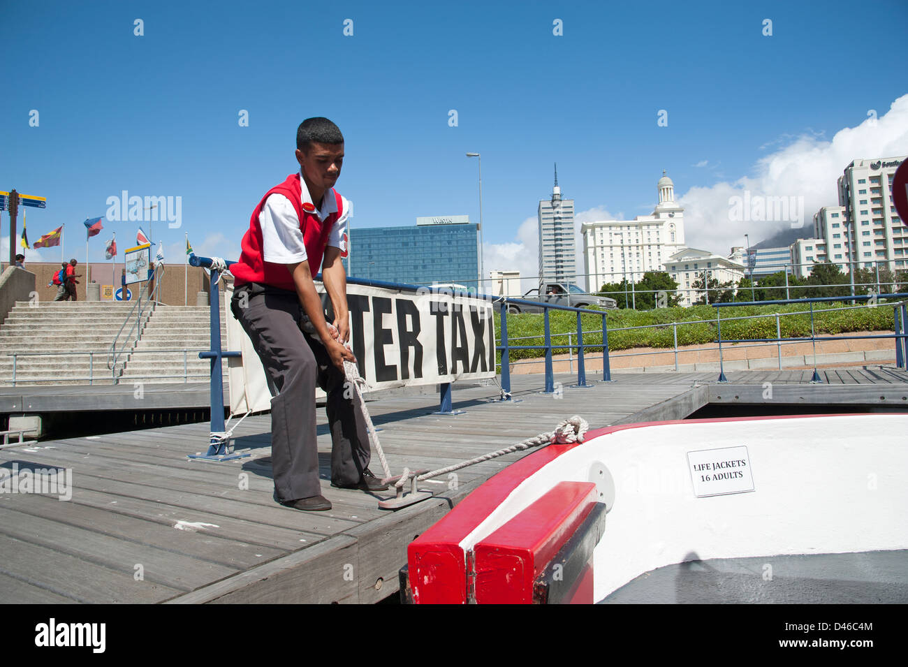 Canal Cruise barca a V&A Waterfront, Città del Capo Sud Africa Crewman tenendo la barca di linea Foto Stock