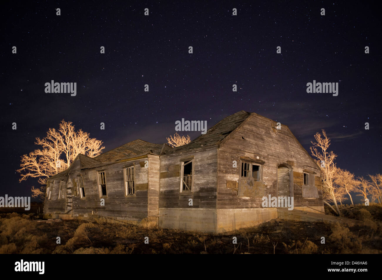 Vecchia casa abbandonata in West Texas sotto una notte cielo dipinto con la luce Foto Stock