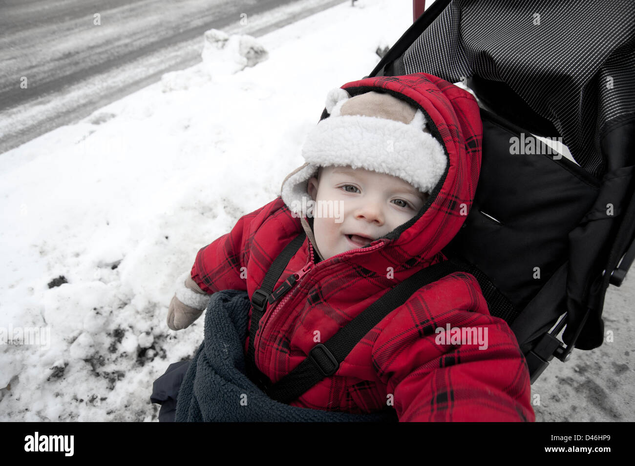 Il bambino nel passeggino in inverno sorridente in telecamera Foto Stock