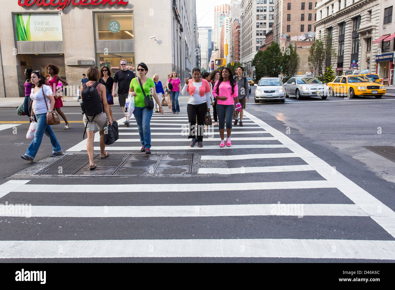 Le persone che attraversano una strada utilizzando un crosswalk nella città di New York Foto Stock