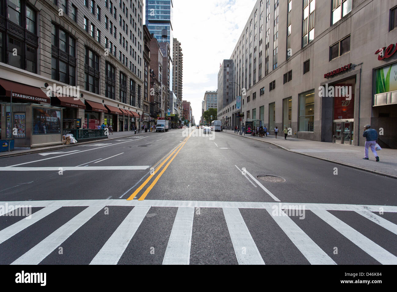 Ampio angolo di fotografia di un quasi vuoto street a New York CIty con linea crosswalk in primo piano Foto Stock