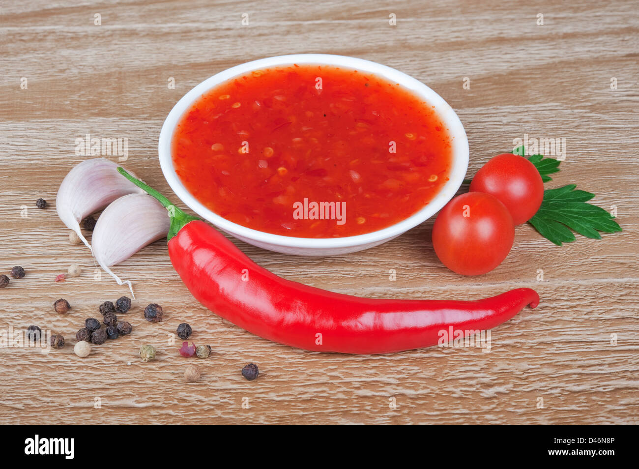 Red Hot Chili salsa sopra lo sfondo di legno Foto Stock