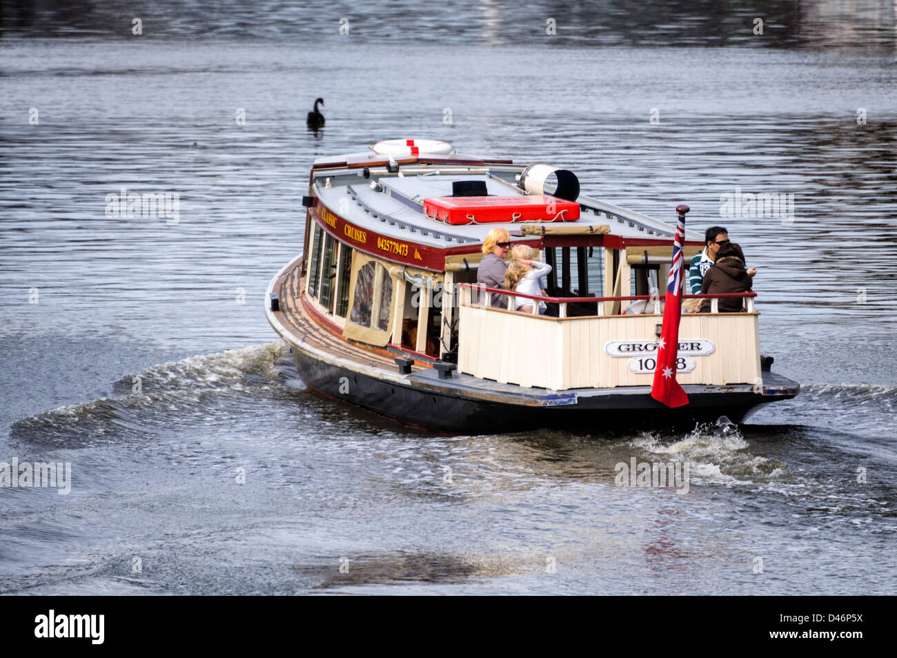 Una barca sul fiume trasporta i suoi passeggeri in serata. Foto Stock