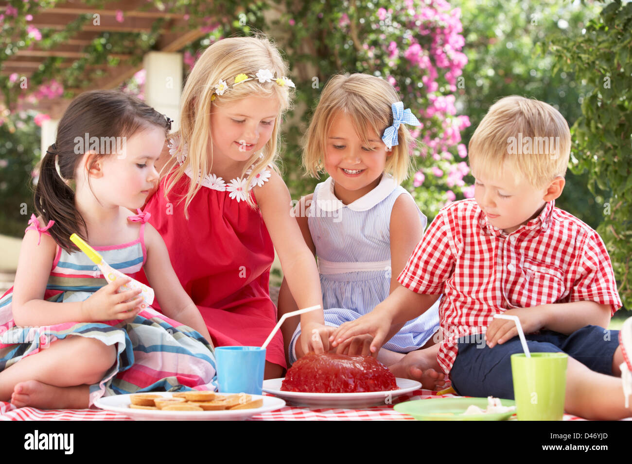 Gruppo di bambini mangiare Jelly in Outdoor Tea Party Foto Stock