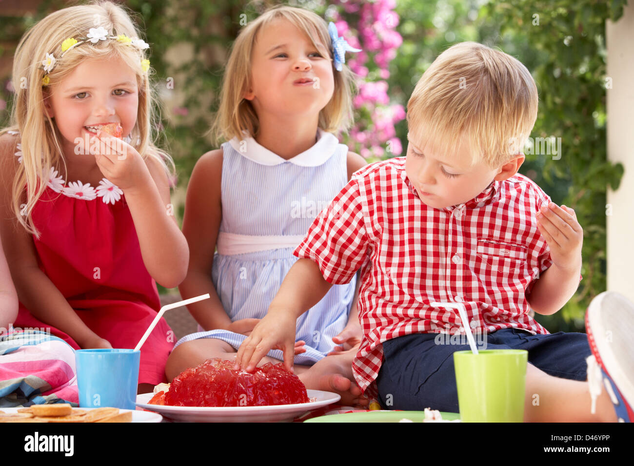 Gruppo di bambini mangiare Jelly in Outdoor Tea Party Foto Stock
