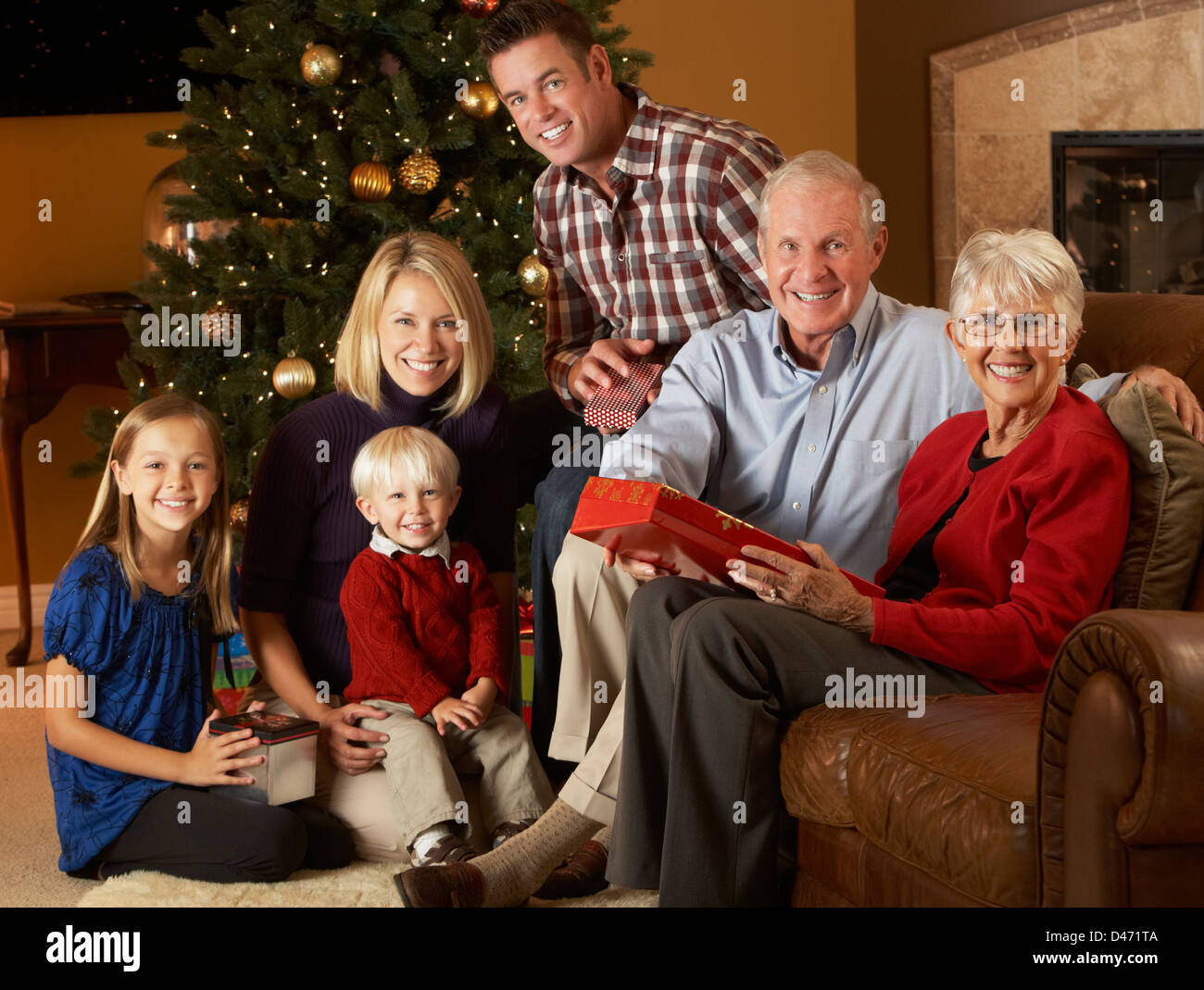 Multi generazione apertura famiglia Regali di natale nella parte anteriore della struttura ad albero Foto Stock