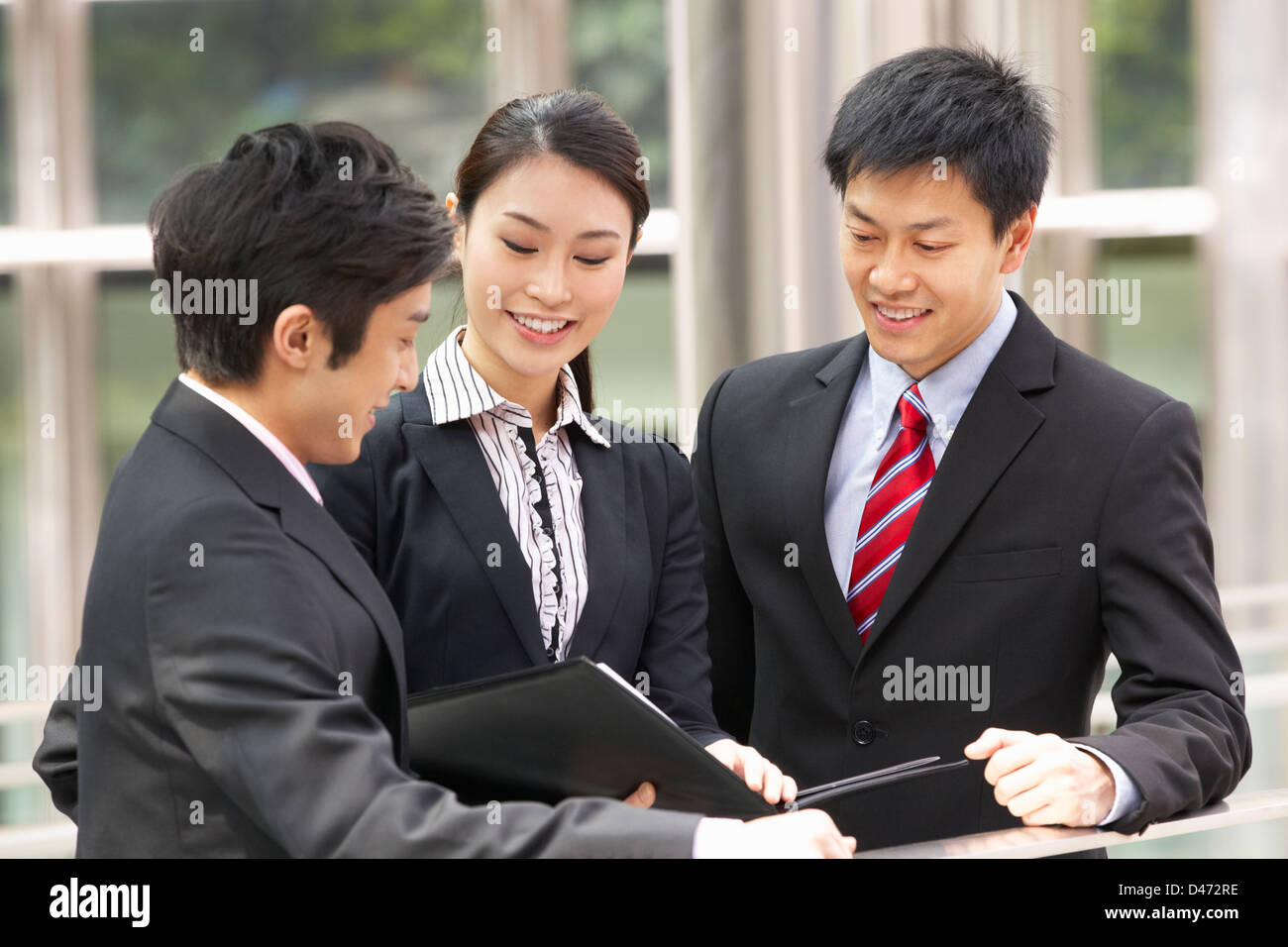 Tre colleghi di lavoro per discutere il documento al di fuori ufficio Foto Stock