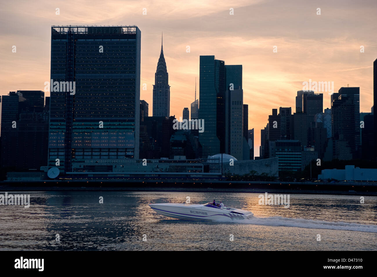 Una velocità del battello lungo la East River di fronte a profilarsi New York skyline della città e nazioni unite & Chrysler edifici. Foto Stock