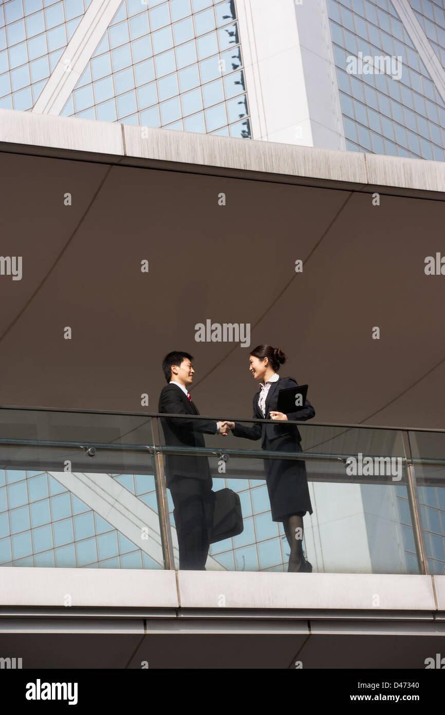Due colleghi di lavoro che stringe la mano al di fuori di Edificio per uffici Foto Stock