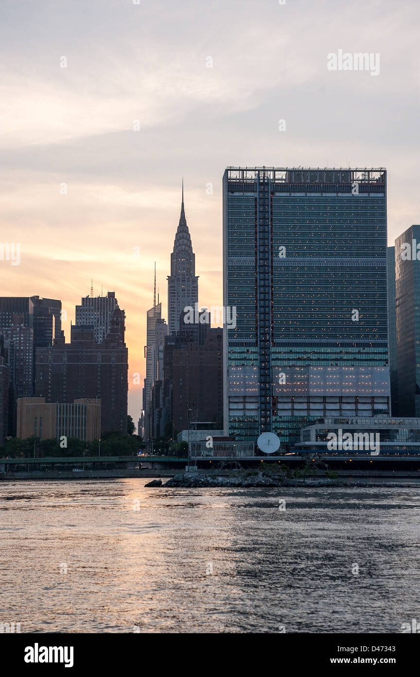 Silhouette di New York skyline della città con le Nazioni Unite e Chrysler edifici su East River al tramonto. Foto Stock