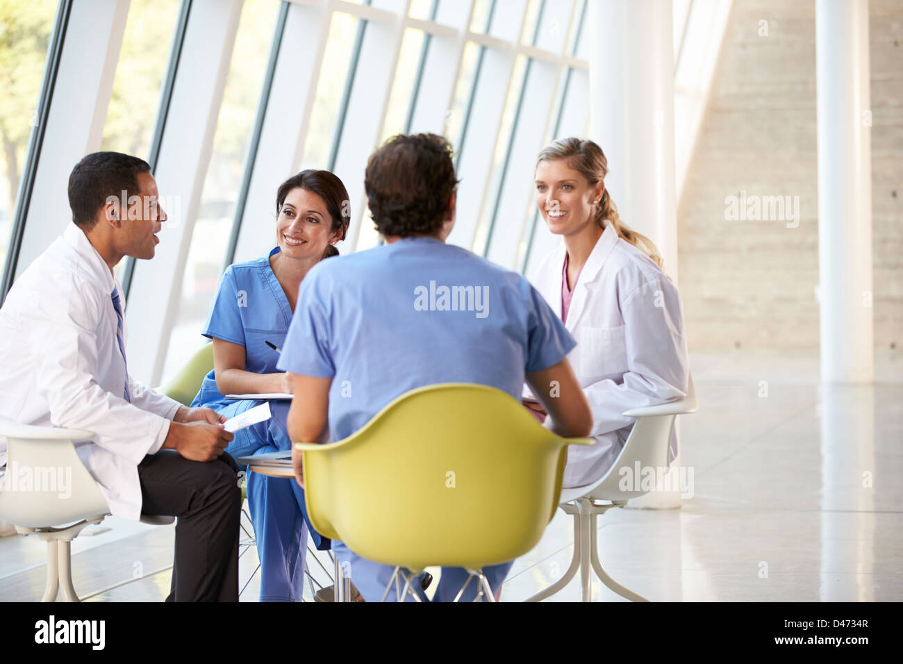 Team di medici riuniti intorno al tavolo in ospedale moderno Foto Stock