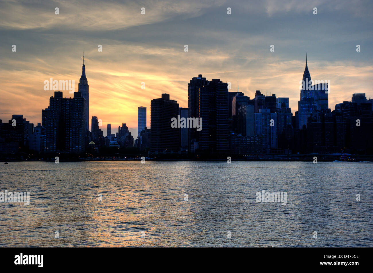 Silhouette di New York skyline della città con l'Empire State Building e Chrysler edifici su East River dopo il tramonto . Foto Stock